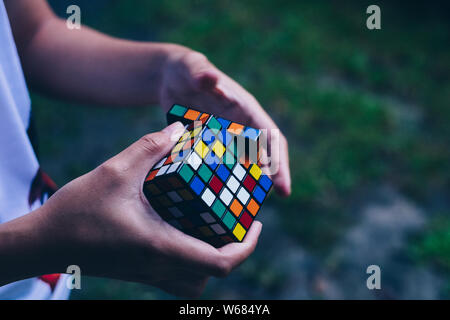 NORALA, PH-Jun 16, 2019: Rubik's Cube wurde 1974 von ungarischen Bildhauer und Professor der Architektur Erno Rubik erfunden. Hände von einer jungen Dame versuchen Stockfoto