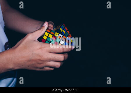 NORALA, PH-Jun 16, 2019: Rubik's Cube wurde 1974 von ungarischen Bildhauer und Professor der Architektur Erno Rubik erfunden. Hände von einer jungen Dame versuchen Stockfoto