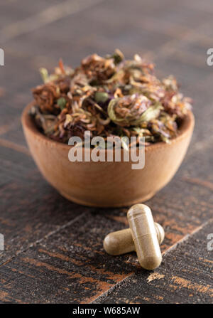 Getrocknete Rotklee Blüten und Blätter auf einem rustikalen Holztisch Stockfoto