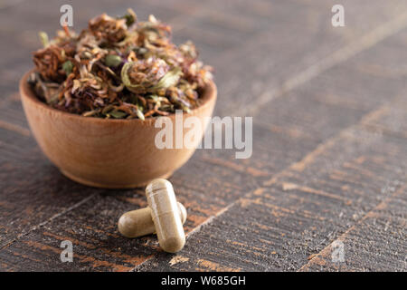 Getrocknete Rotklee Blüten und Blätter auf einem rustikalen Holztisch Stockfoto