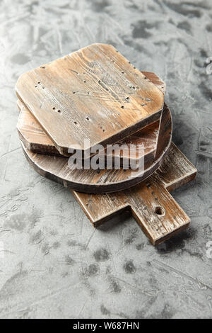 Stapel von verschiedenen hölzerne Schneidbretter auf grauem Hintergrund. Stockfoto