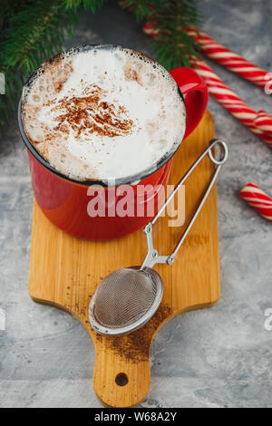 Weihnachten rot emaillierten Becher mit heißer Schokolade und Sahne, Zimtstangen, Anis Sterne und Herzhaftes shortbread Sugar Cookies, Zweige Fichte und c Stockfoto