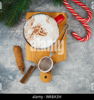 Weihnachten rot emaillierten Becher mit heißer Schokolade und Sahne, Zimtstangen, Anis Sterne und Herzhaftes shortbread Sugar Cookies, Zweige Fichte und c Stockfoto