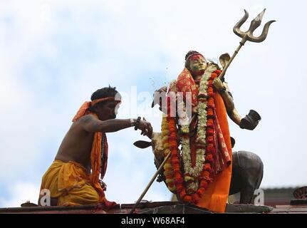 Kathmandu, Nepal. Juli 31, 2019. Ein hinduistischer Priester gießt Milch, als er Gebete Angebote von Lord Shiva an Shiva Tempel zu Idol während des heiligen Monats Shrawan. Credit: Archana Shrestha/Pacific Press/Alamy leben Nachrichten Stockfoto
