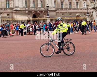 Ein Polizist auf einem Fahrrad auf Aufgabe außerhalb der Buckingham Palace in London, England Stockfoto