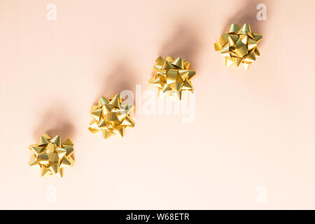 Gold Muster Bögen. festliche Dekoration, Konfetti, Bänder isoliert auf hellen Hintergrund. Festliche Party Kulisse. Geschenkverpackung. Moderne Weihnachtsgeschenke Stockfoto