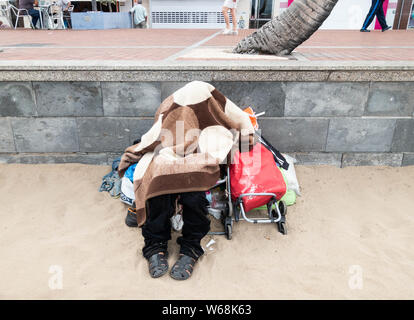 Obdachlose Person schlafen am Strand in Spanien Stockfoto