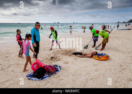 Touristen werden in Sand, White Beach, Boracay, Aklan Provinz der Philippinen. Stockfoto