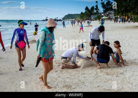 Touristen werden in Sand, White Beach, Boracay, Aklan Provinz der Philippinen. Stockfoto