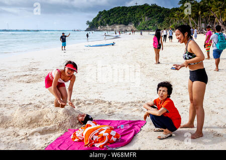 Touristen werden in Sand, White Beach, Boracay, Aklan Provinz der Philippinen. Stockfoto