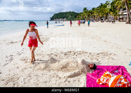 Touristen werden in Sand, White Beach, Boracay, Aklan Provinz der Philippinen. Stockfoto