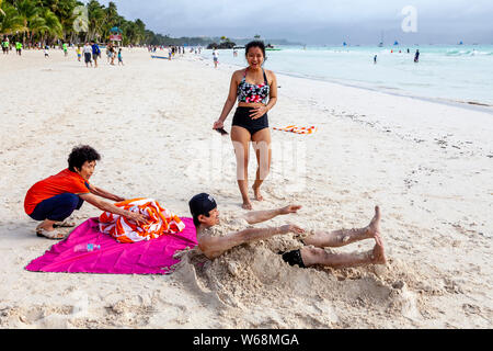 Touristen werden in Sand, White Beach, Boracay, Aklan Provinz der Philippinen. Stockfoto