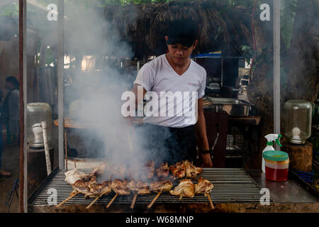 Ein Mann Kocht das Fleisch auf den Grill, Boracay, Aklan Provinz, die Philippinen Stockfoto