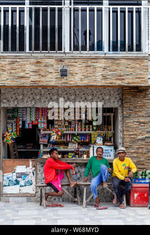 Drei Filipinos außerhalb eines Shop, Boracay, Aklan Provinz, die Philippinen Sitzen Stockfoto