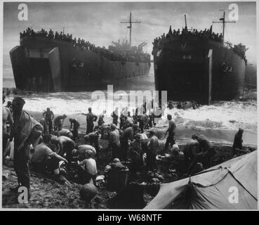 Zwei Coast Guard - Bemannte LST's öffnen ihre große Backen in der Brandung, das auf Leyte Island Beach wäscht, als Soldaten Streifen unten und sandsack Piers bauen, um die Rampen bis zur Geschwindigkeit entladen.; Allgemeine Hinweise: Verwenden Sie Krieg und Konflikt Nummer 1210 bei der Bestellung eine Reproduktion oder Anforderung von Informationen zu diesem Bild. Stockfoto