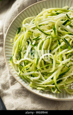 Raw Green Bio Zucchini Nudeln Zoodles in eine Schüssel geben. Stockfoto