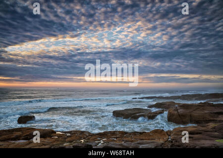 Am Abend licht Wärme auf die Brandung und Basalt Shoreline entlang der zentralen Oregon Coast in Yachats. Stockfoto