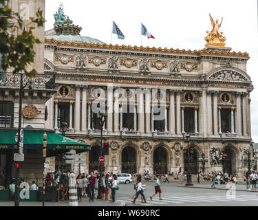 Paris, Frankreich, 19. JULI 2014: Blick auf die Opéra National de Paris und Straße mit Cafe. Große Oper (Opéra Garnier) ist berühmt neo-barocken Gebäude in P Stockfoto