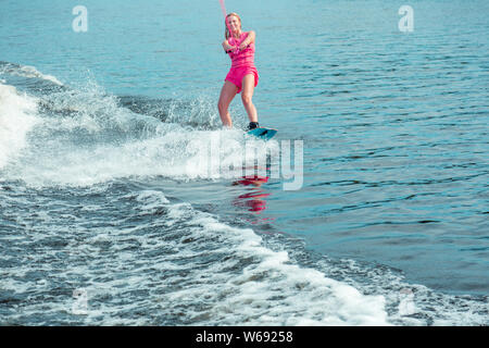 Wakeboarder trägt einen rosa Leben Jacke und Hose Stockfoto