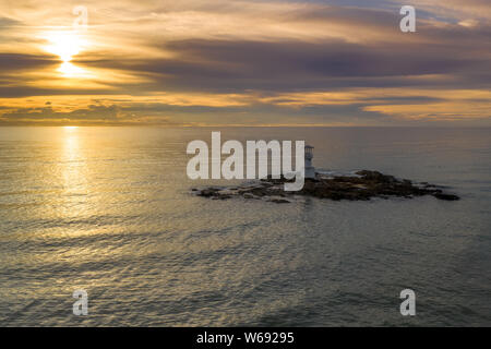 Antenne drone Ansicht einer Leuchtturm bei Sonnenuntergang über einem tropischen Meer (Khao Lak, Thailand) Stockfoto