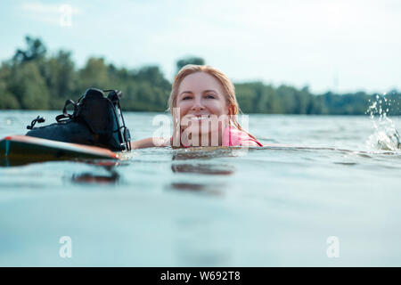 Schönen Lächeln kaukasische Frau schwimmend im Wasser Stockfoto