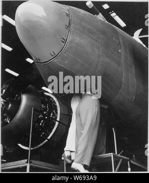 Handwerker auf dem Vega-Flugzeuge Pflanze, Burbank, Kalifornien zwei Frauen der Beschäftigten durch die Luke des Bombardier arbeiten.; Allgemeine Hinweise: Verwenden Sie Krieg und Konflikt Nummer 805 bei der Bestellung eine Reproduktion oder Anforderung von Informationen zu diesem Bild. Stockfoto