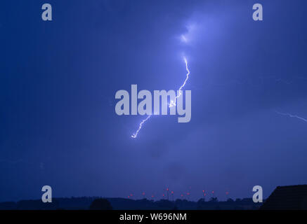 Pokrent, Deutschland. Juli 31, 2019. Ein Blitz kann über eine Windenergieanlage bei einem starken Gewitter gesehen werden. Der Deutsche Wetterdienst hatte Mecklenburg-vorpommern starke lokale Gewitter gewarnt, manchmal mit Starkregen um 20 Liter pro Quadratmeter und Stunde. Credit: Jens Büttner/dpa-Zentralbild/dpa/Alamy leben Nachrichten Stockfoto