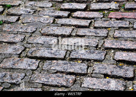 Traditionelle Kopfsteinpflaster in einer nassen Kopfsteinpflasterstraße in Stockport, Greater Manchester, Großbritannien. Stockfoto