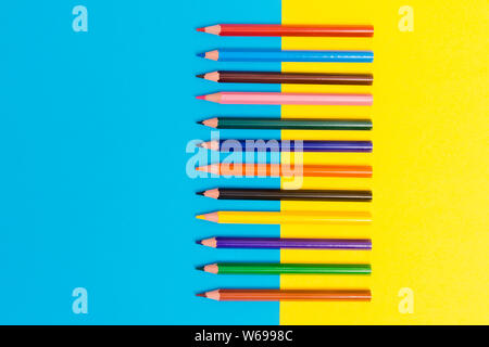 Zurück zu scool - Bleistifte detail. Farbige scharfe Bleistifte Detail in einer Reihe, isoliert auf Blau und Gelb Stockfoto