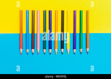 Zurück zu scool - Bleistifte detail. Farbige scharfe Bleistifte Detail in einer Reihe, isoliert auf Blau und Gelb Stockfoto