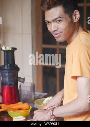 14. April 2019 - Kediri, Indonesien : ein junger indonesischer Mann, der Saft mit einem langsamen Entsafter zubereitete. Stockfoto