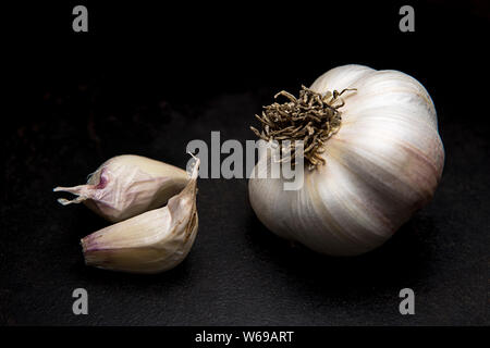 Eine feine art studio Foto von einer rohen Knoblauch Zwiebel und ein paar Nelken. Stockfoto