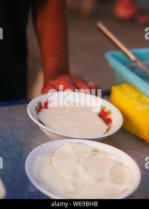 Verkäufer bereit tahok für Kunden. Tahok ist ein Pudding - wie Teller mit einem unverwechselbaren süßen Geschmack der javanischen Zucker. Stockfoto