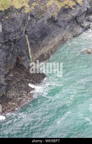 Seascape der Ebbe Zone auf eine Felswand mit smaragdgrünem Wasser. St Agnes head, North Cornwall, UK. Stockfoto