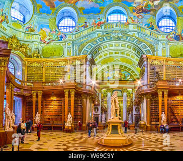 Wien, Österreich - 2. März, 2019: Der große Innenraum der Prunksaal der Nationalbibliothek mit Vintage Bücherschränke, Bücher, Marmor statue des Kaisers Charl Stockfoto