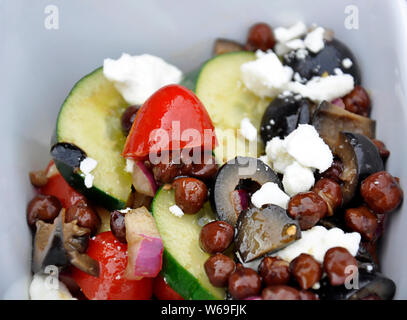 Essen griechische Bohnensalat closeup in einem weißen Teller. Nahrhafte, gesunde Ernährung auf pflanzlicher Basis essen und Whole Foods mit Gurken, Tomaten, Oliven, Stockfoto