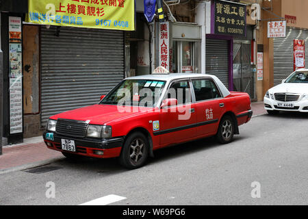 Red Hong Kong Taxi geparkt auf der Straßenseite in Hongkong Stockfoto