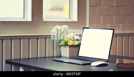 Seitenansicht der offenen leerer Bildschirm Laptop in modernen und komfortablen Arbeitsplatz mit Dekorationen Stockfoto
