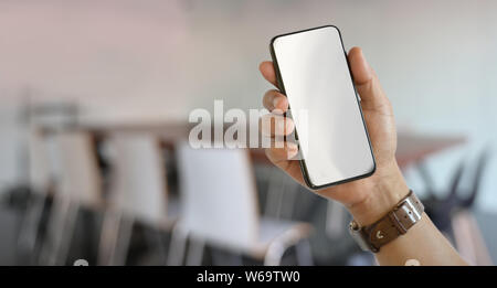 Nahaufnahme der rechten Hand Mann mit leerer Bildschirm Smartphone mit verschwommenen Hintergrund Stockfoto