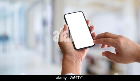 7/8-Ansicht von Mann mit leerer Bildschirm Smartphone mit verschwommenen Hintergrund Stockfoto