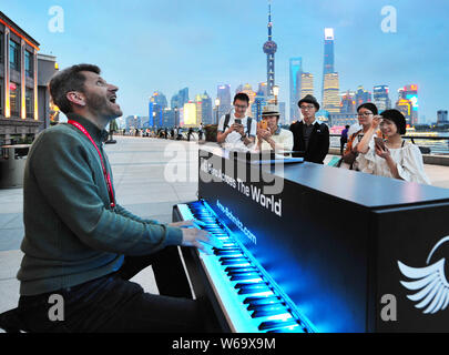 Deutsche Straßenmusiker Arne Schmitt spielt Klavier und singt auf dem Bund in Puxi, Shanghai, China, 4. Juni 2018. Stockfoto