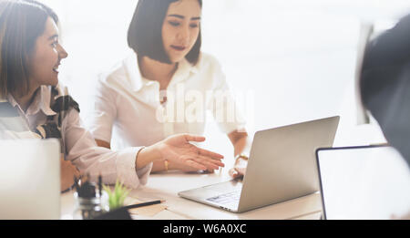 Zwei schöne junge asiatische Geschäftsfrauen Austausch ihrer Ideen in der Anlagestrategie mit Laptop Stockfoto