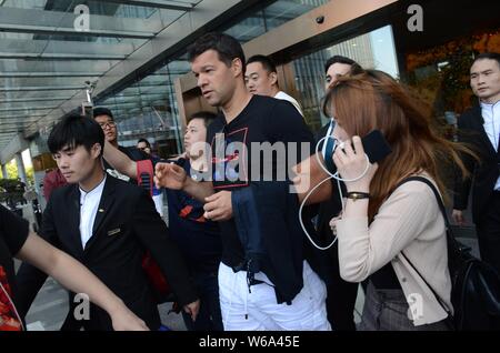 Deutsche ehemaliger Spieler Michael Ballack, am höchsten, wird von Fans und Leibwächtern umgeben, wie er ein Hotel verlässt mit seiner Freundin Natacha Tannous in Shangh Stockfoto