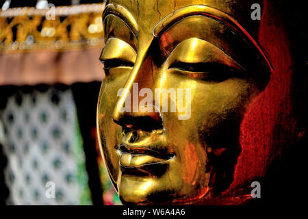 Nahaufnahme von Messing Statue von Buddha zeigt Gesicht mit ruhigem Ausdruck und Reiche metallische Farben und Texturen Stockfoto