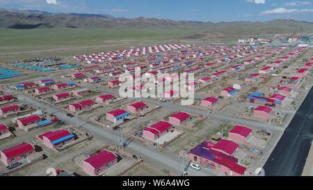 Luftbild der Neuen Residenz der Kasachen in die roten Dächer aufgereiht auf einer Wiese in Yiwu County, Hami Stadt im Nordwesten Chinas Xinjiang Uyghur Autonomou Stockfoto