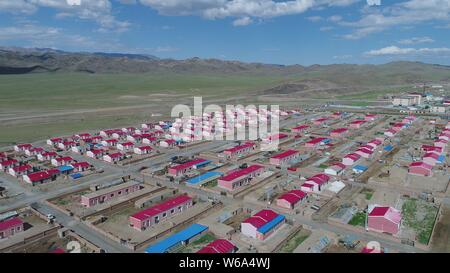 Luftbild der Neuen Residenz der Kasachen in die roten Dächer aufgereiht auf einer Wiese in Yiwu County, Hami Stadt im Nordwesten Chinas Xinjiang Uyghur Autonomou Stockfoto