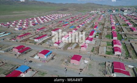 Luftbild der Neuen Residenz der Kasachen in die roten Dächer aufgereiht auf einer Wiese in Yiwu County, Hami Stadt im Nordwesten Chinas Xinjiang Uyghur Autonomou Stockfoto