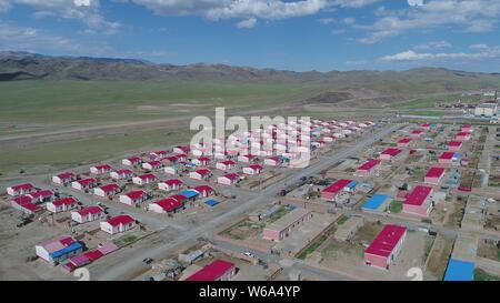 Luftbild der Neuen Residenz der Kasachen in die roten Dächer aufgereiht auf einer Wiese in Yiwu County, Hami Stadt im Nordwesten Chinas Xinjiang Uyghur Autonomou Stockfoto