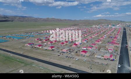 Luftbild der Neuen Residenz der Kasachen in die roten Dächer aufgereiht auf einer Wiese in Yiwu County, Hami Stadt im Nordwesten Chinas Xinjiang Uyghur Autonomou Stockfoto