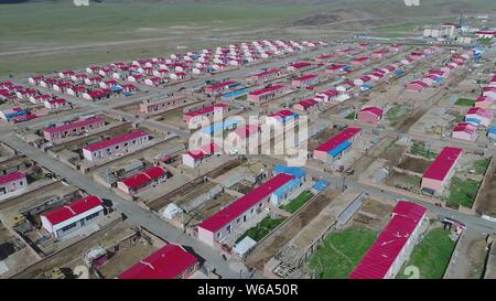 Luftbild der Neuen Residenz der Kasachen in die roten Dächer aufgereiht auf einer Wiese in Yiwu County, Hami Stadt im Nordwesten Chinas Xinjiang Uyghur Autonomou Stockfoto